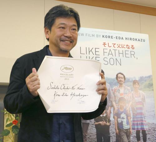 記者会見で審査員賞の賞状を手に笑顔を見せる、「そして父になる」の是枝裕和監督