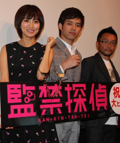 映画「監禁探偵」初日舞台あいさつで、手錠をつなぐ夏菜（左）と三浦貴大。右は及川拓郎監督