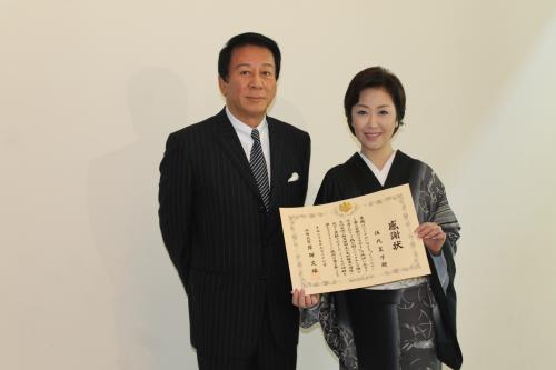 岸田外務大臣からもらった感謝状を手に笑顔の伍代夏子と杉良太郎