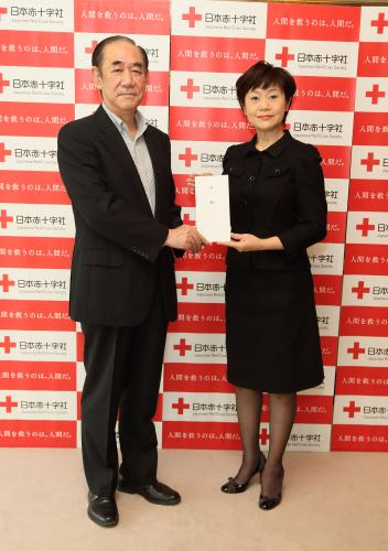 日本赤十字社の大塚義治副社長に１００万円の目録を手渡す神野美伽（右）