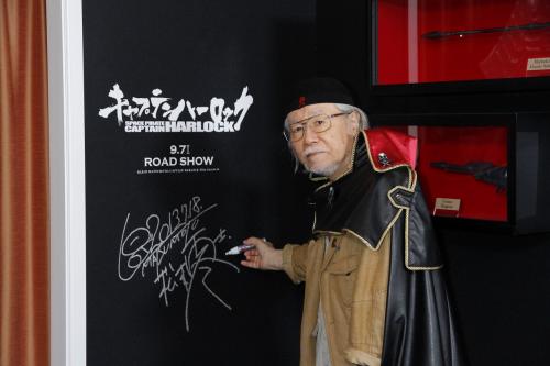 「キャプテン　ハーロック」のコンセプトルームの壁にサインする松本零士氏
