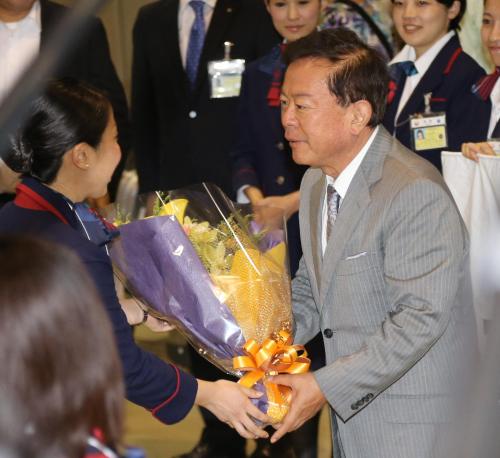 成田空港に到着し日航職員から花束を贈られる猪瀬東京都知事