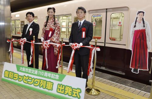 大阪市営地下鉄御堂筋線の「復刻ラッピング列車」の出発式でテープカットをする杏（中央）