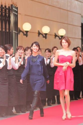 「アニヴェルセル　カフェ＆レストランリニューアルオープン記念イベントで従業員の拍手に迎えられ、レッドカーペットを歩く剛力彩芽（左）と米倉涼子