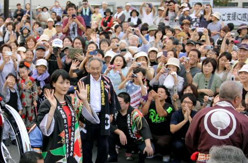 岩手県久慈市で開かれた秋祭りのパレードで、集まった大勢の人たちに手を振る能年玲奈（手前左）