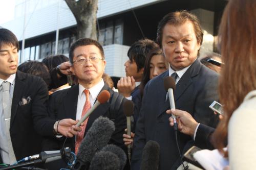 東京地裁前で報道陣の取材に応じる伊藤芳朗弁護士（左）と甲斐智陽こと高橋茂氏