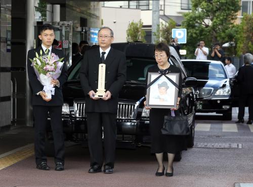 桜塚やっくんの棺を乗せた霊柩車の前で、一礼する（左から）弟・斎藤雅士さん、父・充さん、遺影を持つ母・美佐緒さん