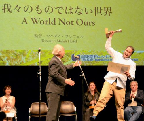 山形国際ドキュメンタリー映画祭で、大賞を受賞し喜ぶ「我々のものではない世界」のマハディ・フレフェル監督（右）