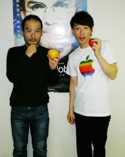 映画「スチーブ・ジョブズ」のポスターの前でポーズを取る、森直樹（左）と田中匡