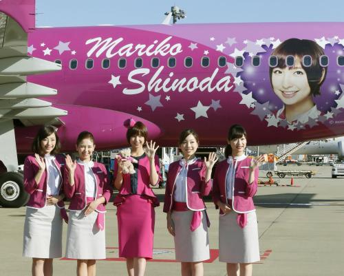 成田空港に到着し、自身の顔が描かれた特別デザイン機の前で客室乗務員とポーズをとる篠田麻里子（中央）