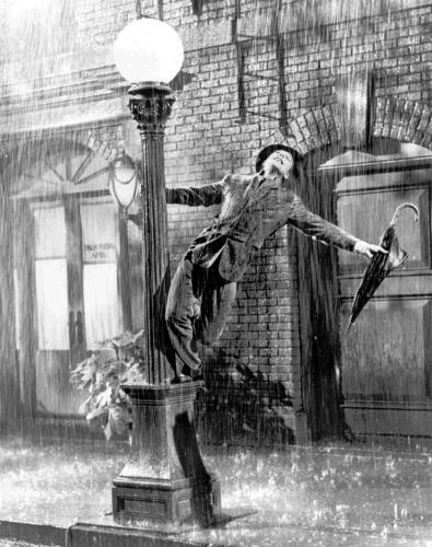 落札されたスーツを着て故ジーン・ケリー氏が歌う映画「雨に唄えば」の一場面（提供写真）