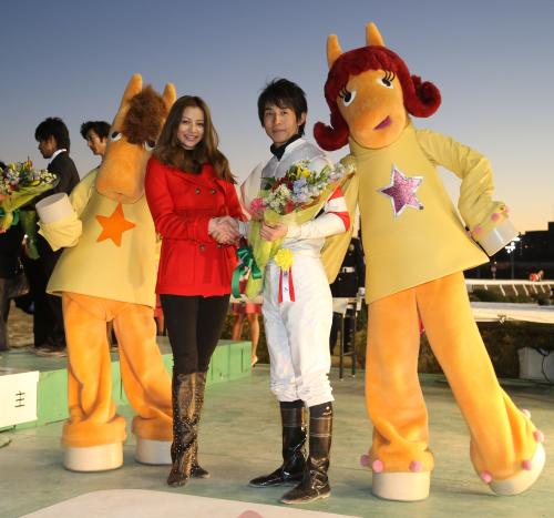 ホッコータルマエで東京大賞典を制した幸英明騎手（中央右）と握手するプレゼンターの香里奈（中央左）。左はＴＣＫのメインキャラクターうまたせ！、右はウマタセーヌ