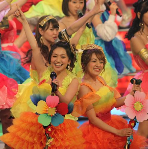 紅白歌合戦の舞台で卒業を発表したＡＫＢ４８の大島優子（左）は笑顔でヘビーローテーションを歌う。右は涙した高橋みなみ