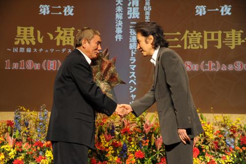 ビートたけし（左）の誕生日を祝って花束を贈り握手を交わす田村正和