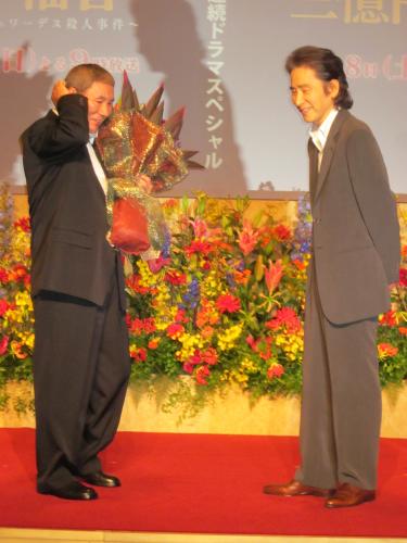 松本清張二夜連続ドラマスペシャルの制作発表で田村正和（右）から誕生日祝いの花束を贈られ照れるビートたけし