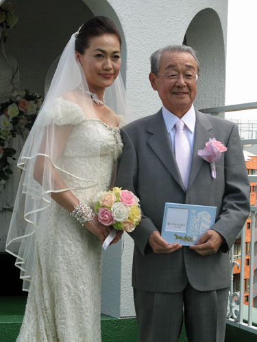 ０９年６月、イベントに夫婦で登場した山本文郎さんとウエディングドレス姿の由美子夫人