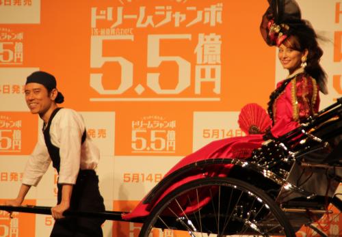 「ジャンボ宝くじ」新ＣＭキャラクターに就任発表会見で、人力車に乗る米倉涼子。（左は）原田泰造