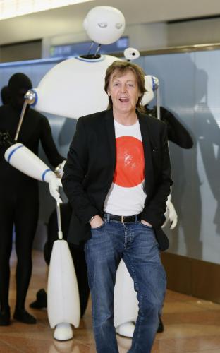 音楽ビデオに登場するロボットと一緒に到着ロビーに姿を現したポール・マッカートニー＝15日午後、羽田空港