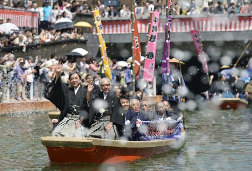 博多座の歌舞伎公演を前に行われた「船乗り込み」で、紙吹雪が舞う中見物客に手を振る坂田藤十郎（先頭右）ら＝29日午後、福岡市博多区
