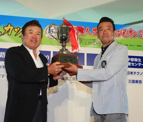 優勝した清水圭（右）は新井泰道大会会長からカップを受け取る