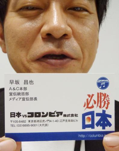 企業ロゴを「日本ＶＳコロンビア」に変更した名刺を手にする日本コロムビアの広報担当者