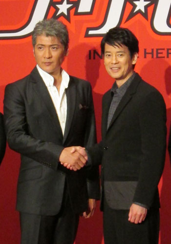 主題歌を歌う吉川晃司（左）と握手する唐沢寿明