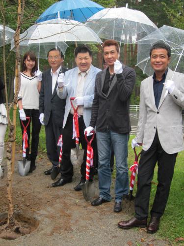 大雨の中、しだれ桜を植樹した（左から）石川えりな、北杜市の白倉政司市長、大江裕、山川豊、中山秀征