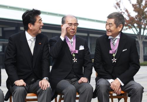 １３年１１月、文化勲章の親授式を終え、記念写真の撮影前に安倍首相と話す高倉健さん（右）。中央は岩崎俊一さん＝宮殿・東庭
