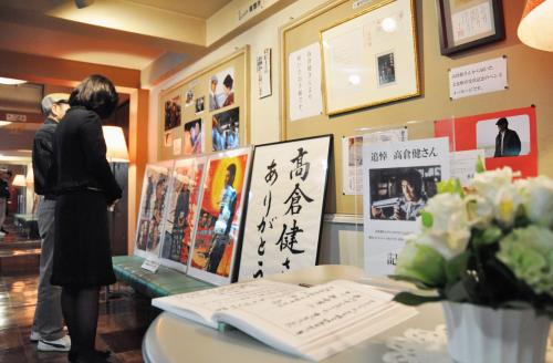 高倉健さんの出演映画のポスターや手紙に見入る来館者