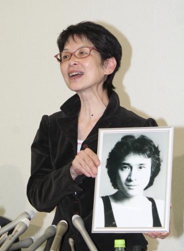 ４２年前の萩原流行さんの写真を手に会見する妻まゆ美さん