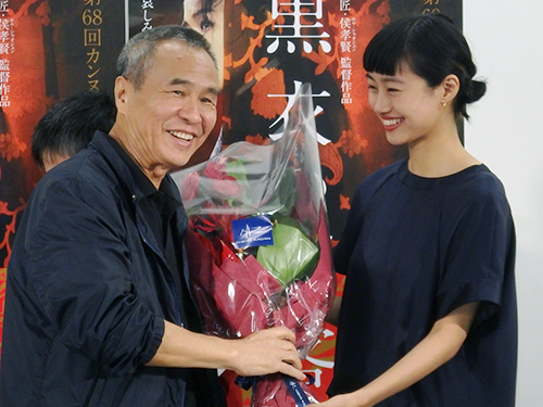 映画「黒衣の刺客」の会見で、ホウ・シャオシェン監督に花束を渡す忽那汐里