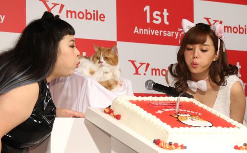 ワイモバイル１周年記念ふてニャン写真集発表会に登場、ＣＭキャラクターのふてニャンを挟んでケーキのろうそくを吹き消す渡辺直美（左）と篠崎愛
