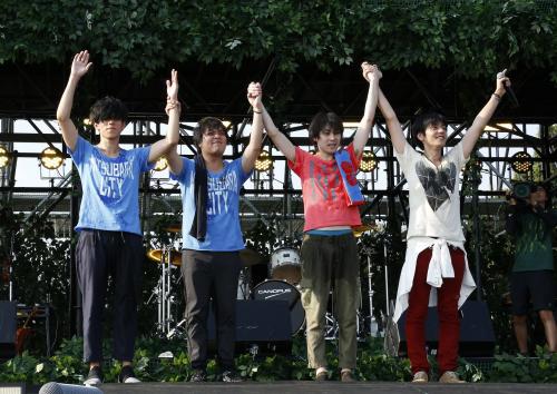 凱旋ライブを終え、手を取り合うｆｌｕｍｐｏｏｌの（左から）尼川元気、阪井一生、小倉誠司、山村隆太