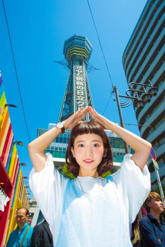 地元の関西から自身初のツアーをスタートさせた三戸なつめ。大阪・通天閣をバックに笑顔。