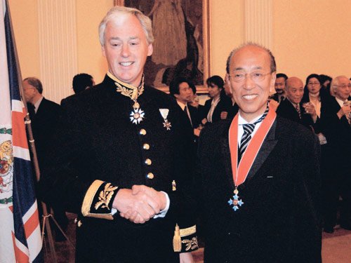 ０３年３月、名誉大英勲章第３位の叙勲式でゴマソール駐日英国大使（左）と握手する蜷川さん