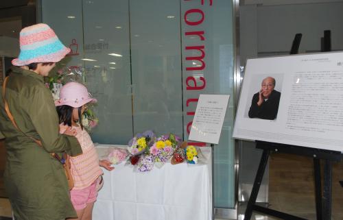 蜷川幸雄さんをしのび、彩の国さいたま芸術劇場に設けられた献花台。親子が追悼していた