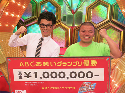 「第３７回ABCお笑いグランプリ」で優勝したセルライトスパの肥後（左）と大須賀。賞金１００万円のボードを手に会心の笑み