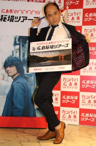 「広島秘境ツアーズ　ツアーデスク」開設発表会に登場した「トレンディエンジェル」の斎藤司は、斎藤工が表紙のガイドブックの横でポーズ