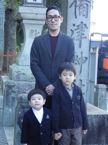 吉備津神社の鳥居前で撮影に応じる（左から）波野哲之、中村勘九郎、波野七緒八
