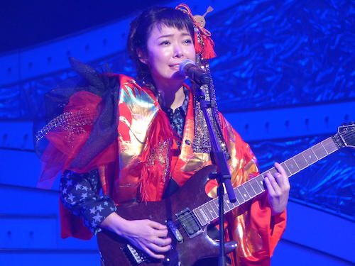 エレキギターを弾きながら歌う田川寿美
