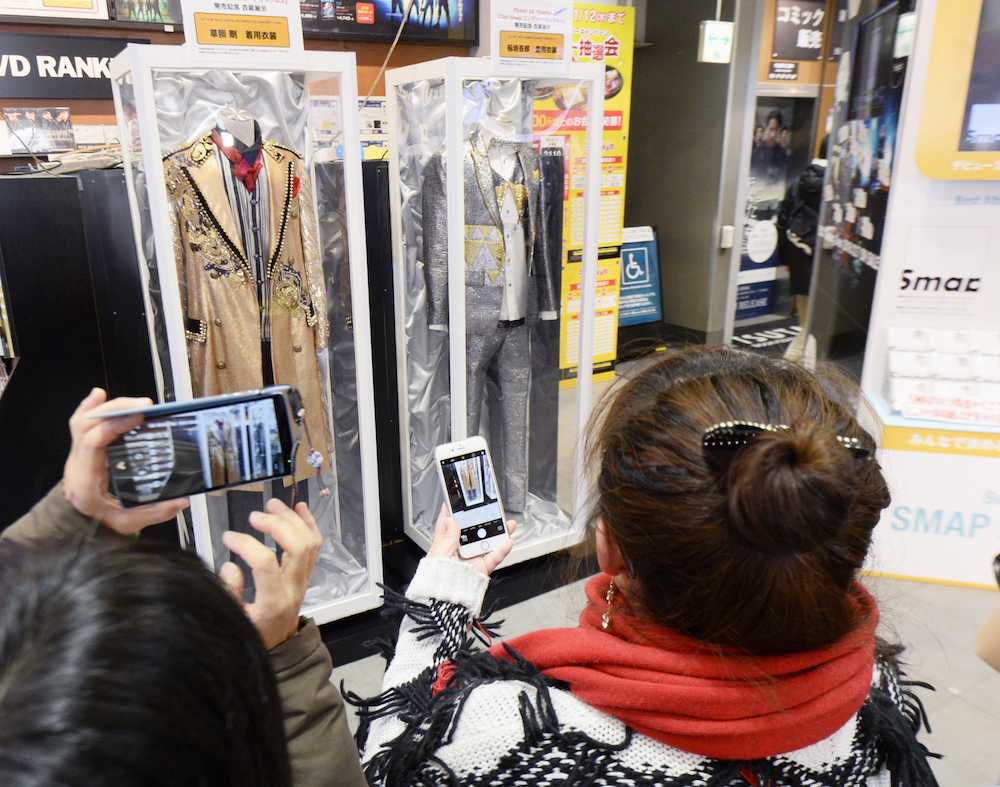 展示されたＳＭＡＰのメンバーの草なぎ剛と稲垣吾郎の衣装をスマートフォンで撮影するファンら