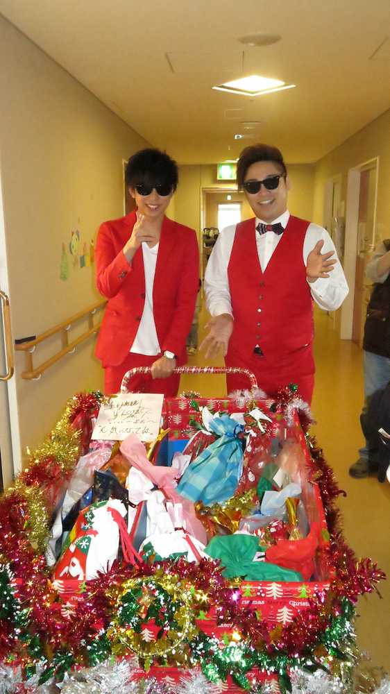 大阪市北区の「北野病院」の小児病棟で子どもたちにクリスマスプレゼントを配る「８・６秒バズーカー」のはまやねん（右）と田中シングル
