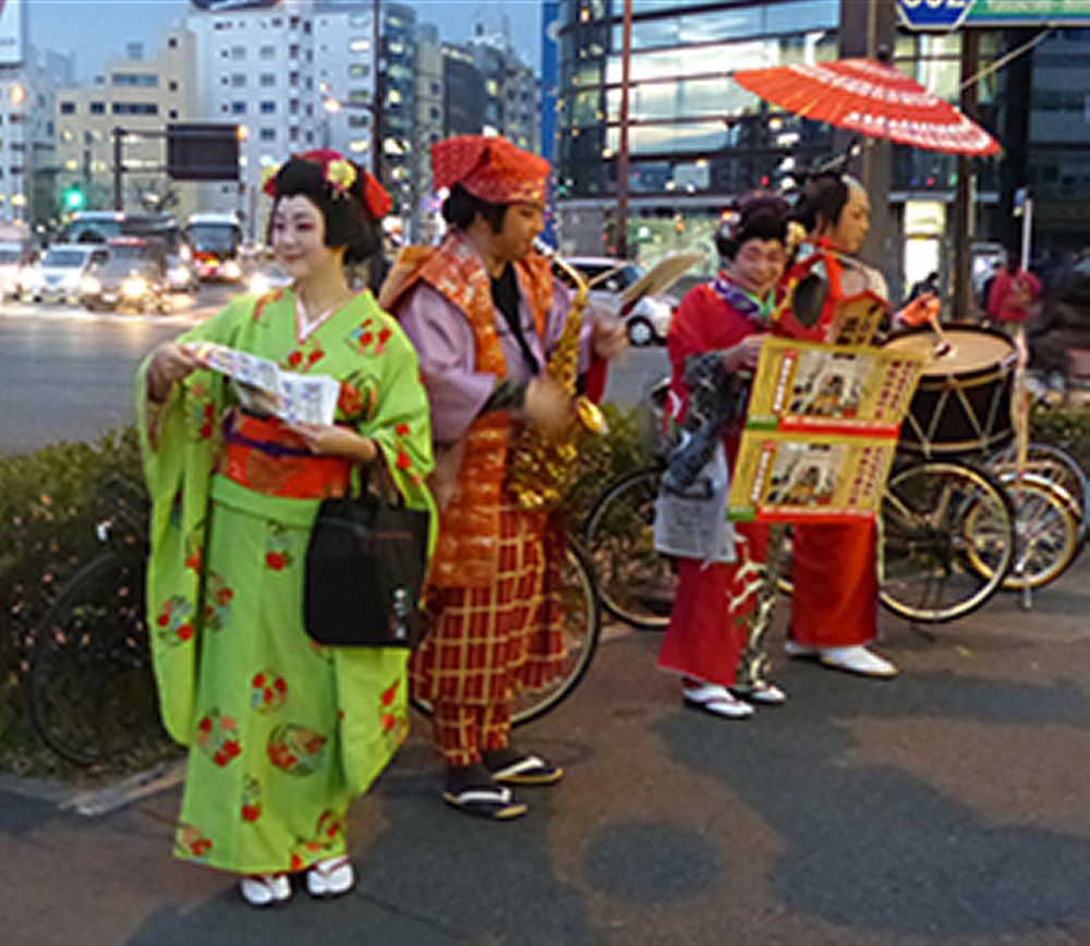 演奏に合わせて路上で宣伝する長田望さん（左端）