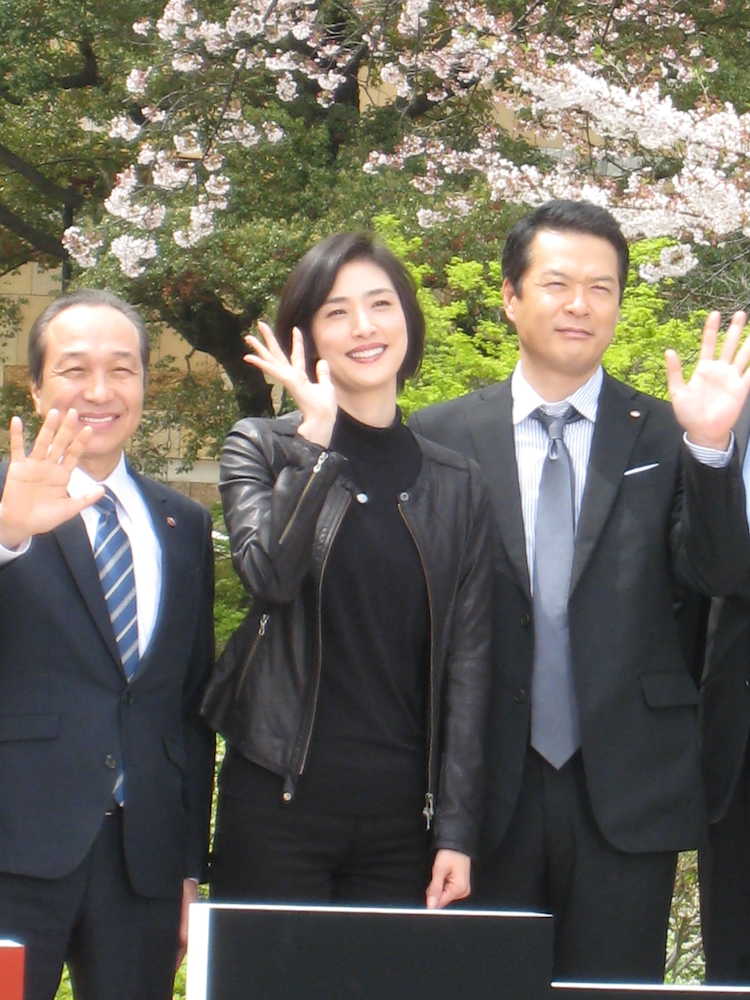 テレビ朝日「緊急取調室」制作発表会見で、桜の木の下で手を振る（左から）小日向文世、天海祐希、田中哲司