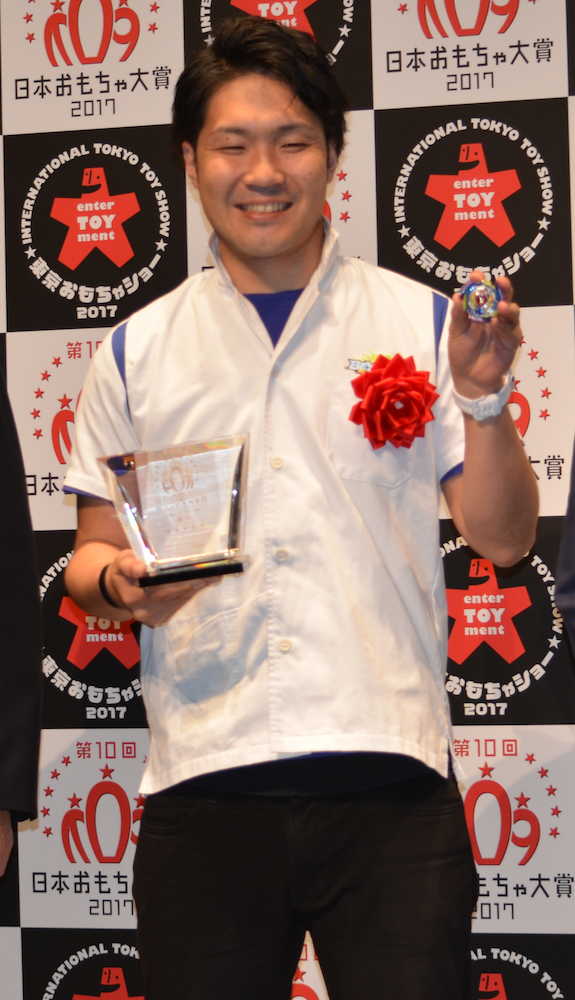 日本おもちゃ大賞のボーイズ・トイ部門で大賞を受賞した「ベイブレードバースト」を手にするタカラトミーの堀川さん