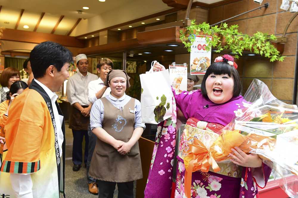 阪ミナミの商店街で挨拶回りする吉本新喜劇初の女座長・酒井藍（右）。ファンから花束、プレゼントをもらい大喜び