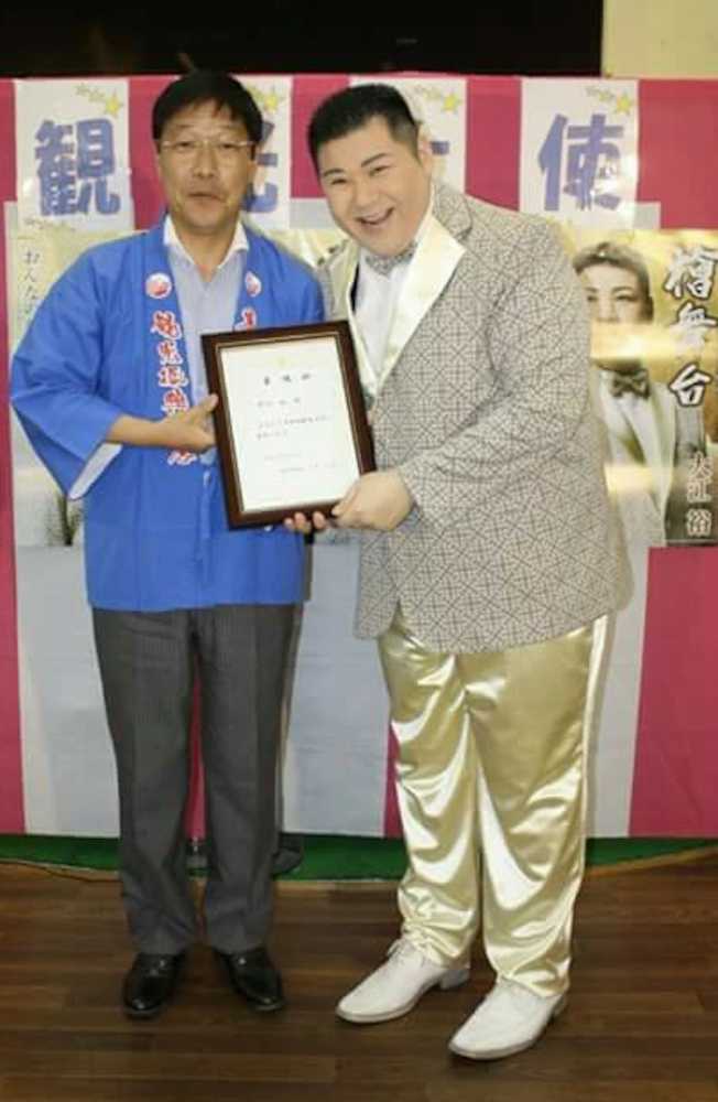 「岸和田観光大使」に任命され、信貴芳則市長（左）から委嘱状を受け取る大江裕