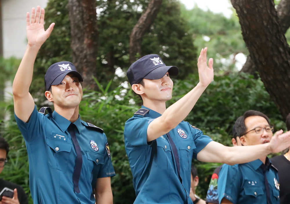 ソウル地方警察庁から出て、集まったファンに手を振る「東方神起」のチャンミン（右）と「ＳＵＰＥＲ　ＪＵＮＩＯＲ」のシウォン