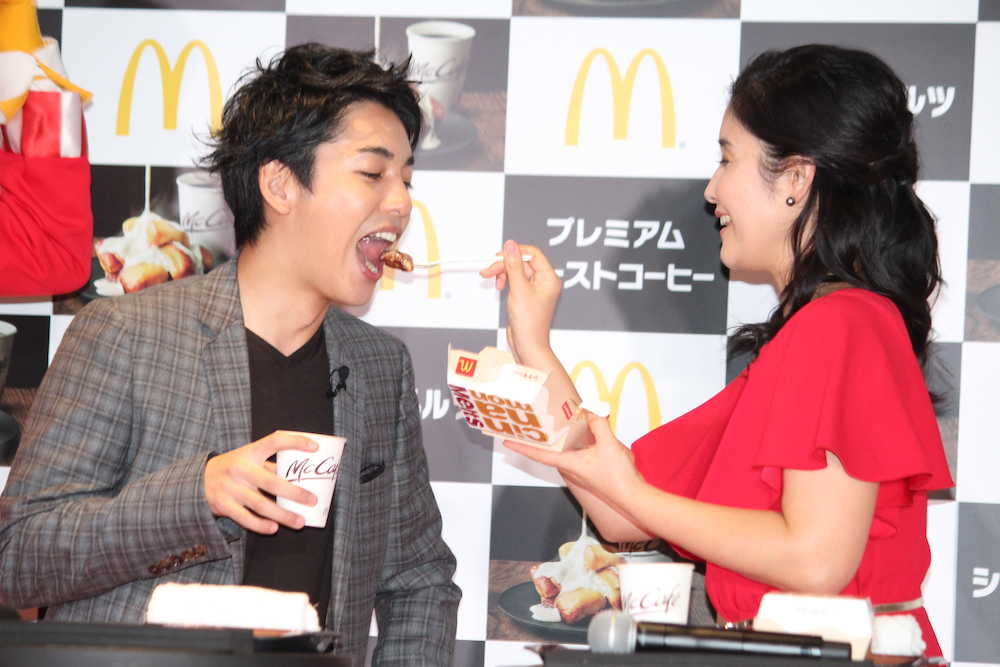 「日本マクドナルド　ＨＯＴ　ＪＡＰＡＮ」発表会で、石田ひかりからシナモンメルツを「あ〜ん」して食べさせてもらう大野拓朗（左）