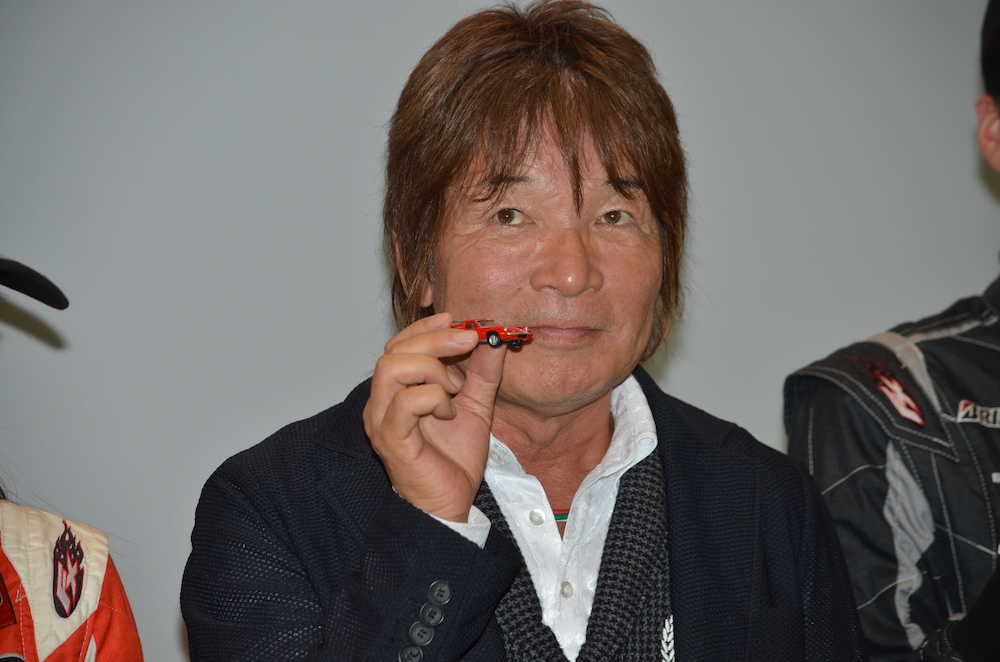 東京モーターショーで２５日に行われた「トミカ」ブースのオープニングイベントに出席した池沢さとし氏。ロータス・ヨーロッパスペシャルのトミカを手に笑顔